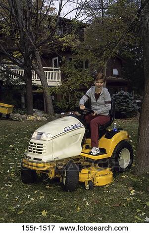Young woman riding a lawn mower View Large Photo Image Stock Photo - Young woman riding a lawn mower. Fotosearch