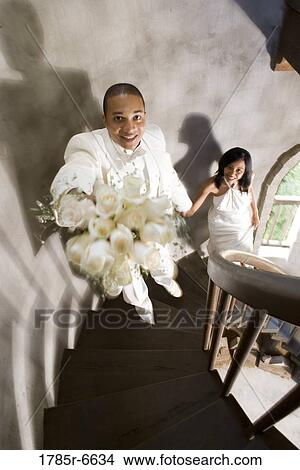 A bride and groom in white climbing up a spiral staircase View Large Photo Image Picture - A bride and groom in white climbing up a spiral staircase. Fotosearch