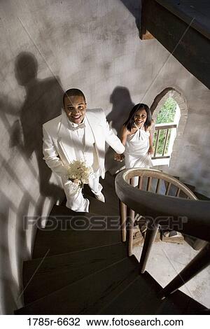 A bride and groom in white climbing up a spiral staircase View Large Photo Image Stock Image - A bride and groom in white climbing up a spiral staircase. Fotosearch