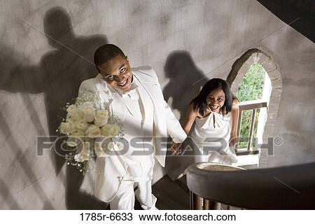 A bride and groom in white climbing up a spiral staircase View Large Photo Image Stock Image - A bride and groom in white climbing up a spiral staircase. Fotosearch