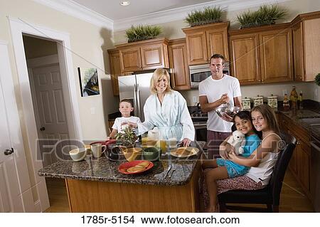Picture - A family having breakfast in the kitchen. Fotosearch