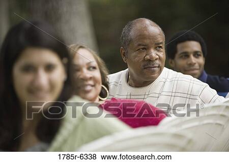 A family sitting on lawn chairs looking behind them View Large Photo Image Stock Photo - A family sitting on lawn chairs looking behind them. Fotosearch