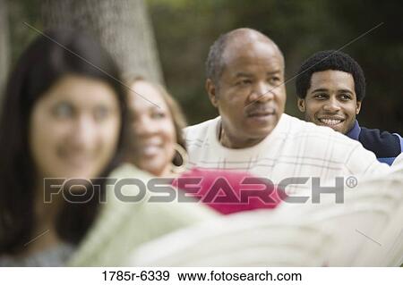 A family sitting on lawn chairs looking behind them View Large Photo Image Stock Photo - A family sitting on lawn chairs looking behind them. Fotosearch