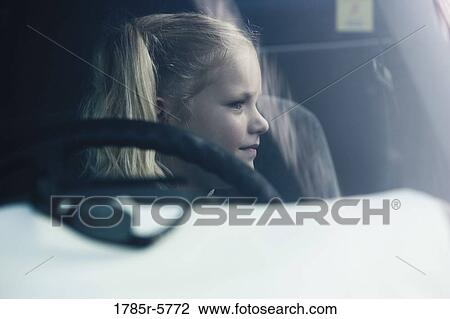 A girl sitting inside a car View Large Photo Image Stock Image - A girl sitting inside a car. Fotosearch