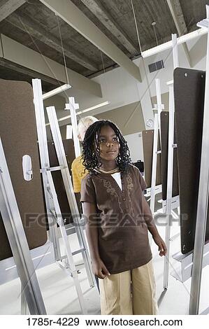 A girl standing at drawing easel in art class View Large Photo Image Stock Photo - A girl standing at drawing easel in art class. Fotosearch