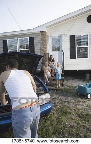 A man looking under the hood of a pickup truck in front of trailer home View Large Photo Image Stock Image - A man looking under the hood of a pickup truck in front of trailer home. Fotosearch