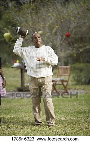 Stock Image - A mature man throwing a football. Fotosearch