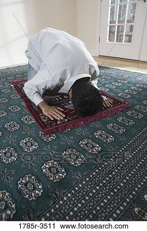 A Muslim man bowing head on a prayer mat View Large Photo Image Stock Image - A Muslim man bowing head on a prayer mat. Fotosearch