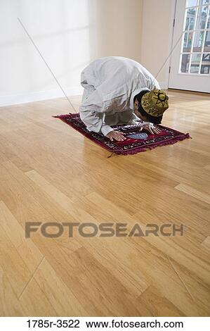 A Muslim man bowing head on a prayer mat View Large Photo Image Stock Image - A Muslim man bowing head on a prayer mat. Fotosearch