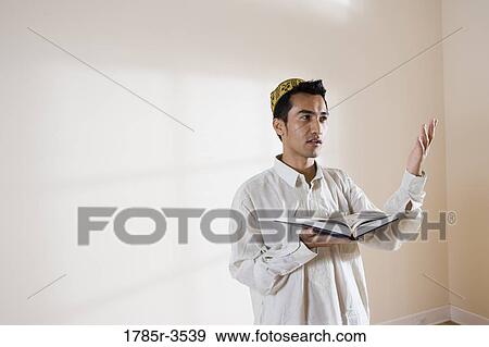A Muslim man holding Koran View Large Photo Image Stock Photo - A Muslim man holding Koran. Fotosearch