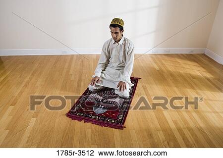 A Muslim man praying on a prayer mat View Large Photo Image Stock Image - A Muslim man praying on a prayer mat. Fotosearch