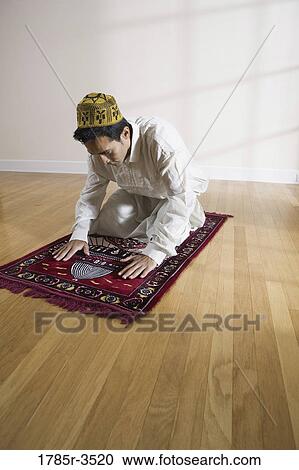 A Muslim man praying on a prayer mat View Large Photo Image Stock Image - A Muslim man praying on a prayer mat. Fotosearch