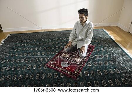 A Muslim man praying on a prayer mat View Large Photo Image Stock Photo - A Muslim man praying on a prayer mat. Fotosearch