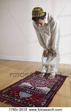 A Muslim man praying on a prayer mat View Large Photo Image Stock Photo - A Muslim man praying on a prayer mat. Fotosearch