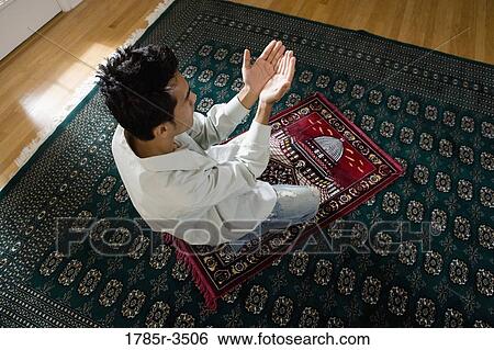 A Muslim man praying on a prayer mat View Large Photo Image Stock Photograph - A Muslim man praying on a prayer mat. Fotosearch