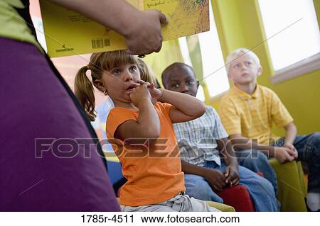 A teacher standing up and reading to young children View Large Photo Image Stock Image - A teacher standing up and reading to young children. Fotosearch