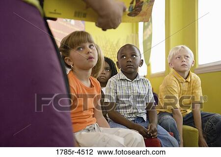 A teacher standing up and reading to young children View Large Photo Image Stock Image - A teacher standing up and reading to young children. Fotosearch