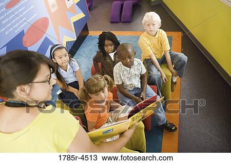 A teacher standing up and reading to young children View Large Photo Image Stock Image - A teacher standing up and reading to young children. Fotosearch