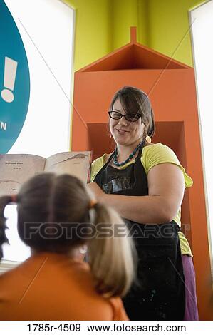 A teacher standing up and reading to young children View Large Photo Image Stock Photo - A teacher standing up and reading to young children. Fotosearch
