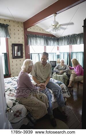 Adult children visiting and comforting senior parents in bedroom View Large Photo Image Stock Photo - Adult children visiting and comforting senior parents in bedroom. Fotosearch