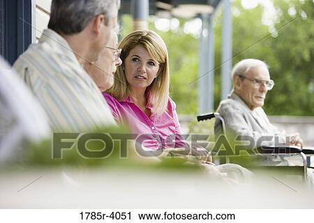 Stock Image - Adult children visiting with elderly parents. Fotosearch