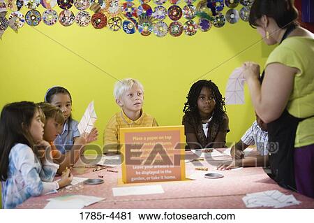 An art teacher demonstrating an art project to her young students in art class View Large Photo Image Stock Image - An art teacher demonstrating an art project to her young students in art class. Fotosearch