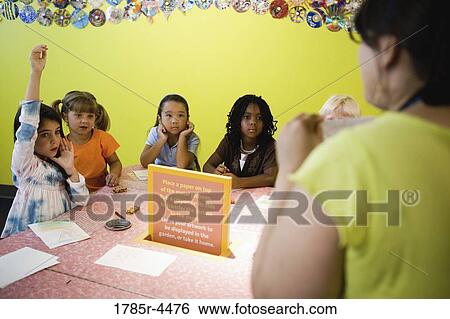 An art teacher demonstrating an art project to her young students in art class View Large Photo Image Stock Photograph - An art teacher demonstrating an art project to her young students in art class. Fotosearch