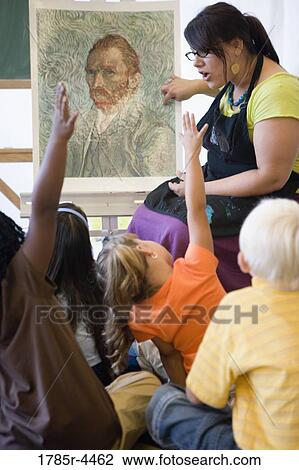 An art teacher showing painting to young students in art class View Large Photo Image Stock Image - An art teacher showing painting to young students in art class. Fotosearch