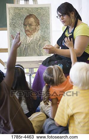 An art teacher showing painting to young students in art class View Large Photo Image Stock Image - An art teacher showing painting to young students in art class. Fotosearch