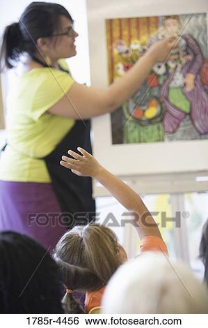 An art teacher showing painting to young students in art class View Large Photo Image Stock Photograph - An art teacher showing painting to young students in art class. Fotosearch
