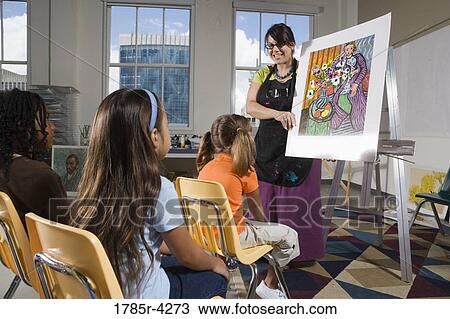 An art teacher standing by easel teaching her young students in art class View Large Photo Image Stock Image - An art teacher standing by easel teaching her young students in art class. Fotosearch