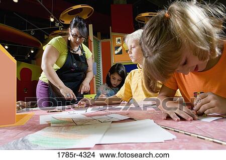 An art teacher teaching her young students in art class View Large Photo Image Picture - An art teacher teaching her young students in art class. Fotosearch