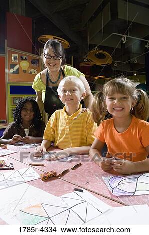 An art teacher teaching her young students in art class View Large Photo Image Picture - An art teacher teaching her young students in art class. Fotosearch