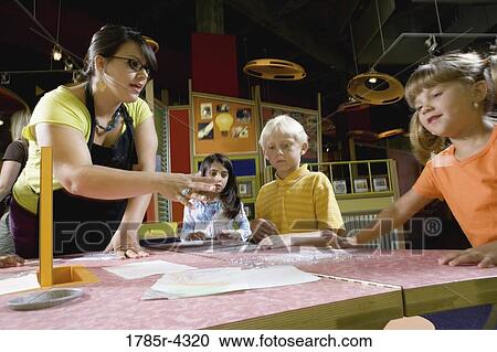 An art teacher teaching her young students in art class View Large Photo Image Stock Image - An art teacher teaching her young students in art class. Fotosearch
