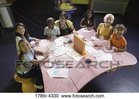 An art teacher teaching her young students in art class View Large Photo Image Stock Image - An art teacher teaching her young students in art class. Fotosearch