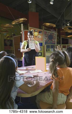 Stock Photo - An art teacher teaching her young students in art class. Fotosearch