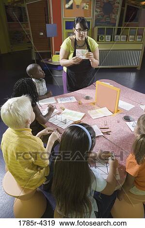 An art teacher teaching her young students in art class View Large Photo Image Stock Photo - An art teacher teaching her young students in art class. Fotosearch