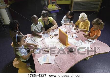An art teacher teaching her young students in art class View Large Photo Image Stock Photo - An art teacher teaching her young students in art class. Fotosearch