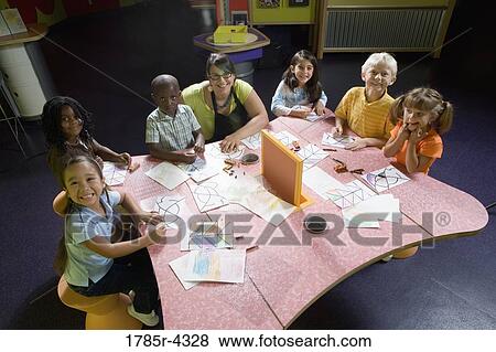 Stock Photo - An art teacher teaching her young students in art class. Fotosearch