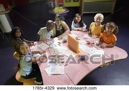 An art teacher teaching her young students in art class View Large Photo Image Stock Photo - An art teacher teaching her young students in art class. Fotosearch