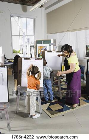 An art teacher teaching students in a classroom View Large Photo Image Stock Image - An art teacher teaching students in a classroom. Fotosearch