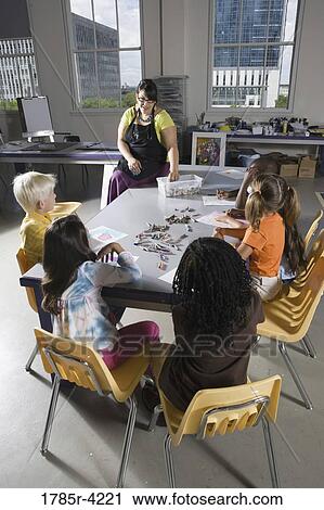 An art teacher teaching young students in art class View Large Photo Image Stock Image - An art teacher teaching young students in art class. Fotosearch