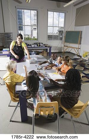 An art teacher teaching young students in art class View Large Photo Image Stock Image - An art teacher teaching young students in art class. Fotosearch