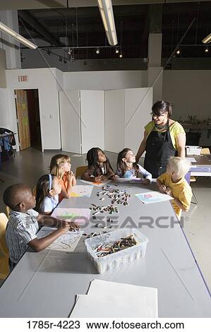 An art teacher teaching young students in art class View Large Photo Image Stock Image - An art teacher teaching young students in art class. Fotosearch