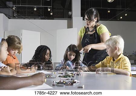 Stock Photo - An art teacher teaching young students in art class. Fotosearch