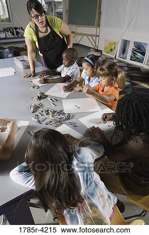An art teacher teaching young students in art class View Large Photo Image Stock Photography - An art teacher teaching young students in art class. Fotosearch