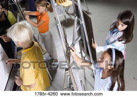 An art teacher with her student drawing on easels in art class View Large Photo Image Stock Image - An art teacher with her student drawing on easels in art class. Fotosearch