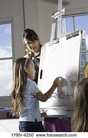 An art teacher with her students drawing on easels in art class View Large Photo Image Stock Image - An art teacher with her students drawing on easels in art class. Fotosearch