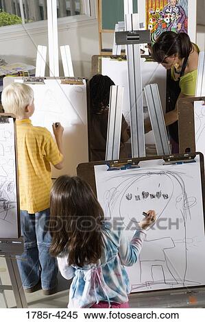 An art teacher with her students drawing on easels in art class View Large Photo Image Stock Photography - An art teacher with her students drawing on easels in art class. Fotosearch