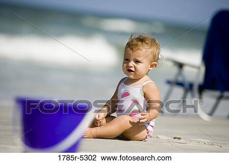 Baby girl sitting on beach View Large Photo Image Stock Image - Baby girl sitting on beach. Fotosearch